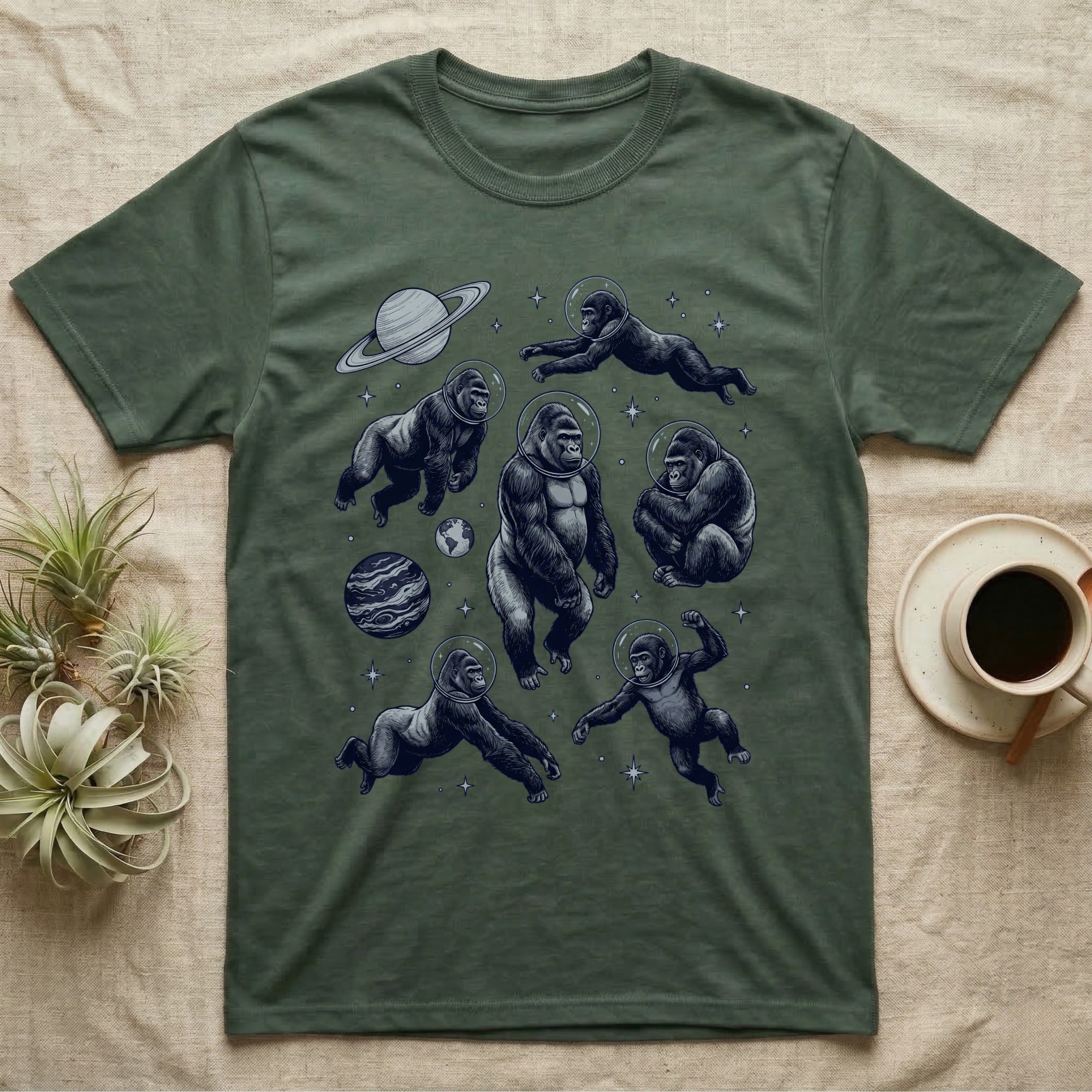 Gorillas in spacesuits float among planets and stars on a green t-shirt.