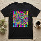 Black t-shirt with psychedelic "Tropical Trip Vibe Shifter" text and chameleon graphic.