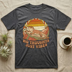 Dark grey t-shirt with a bearded dragon and "NO THOUGHTS JUST VIBES" text.