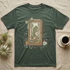 Green t-shirt with framed chameleon illustration, plants, and a potion bottle.
