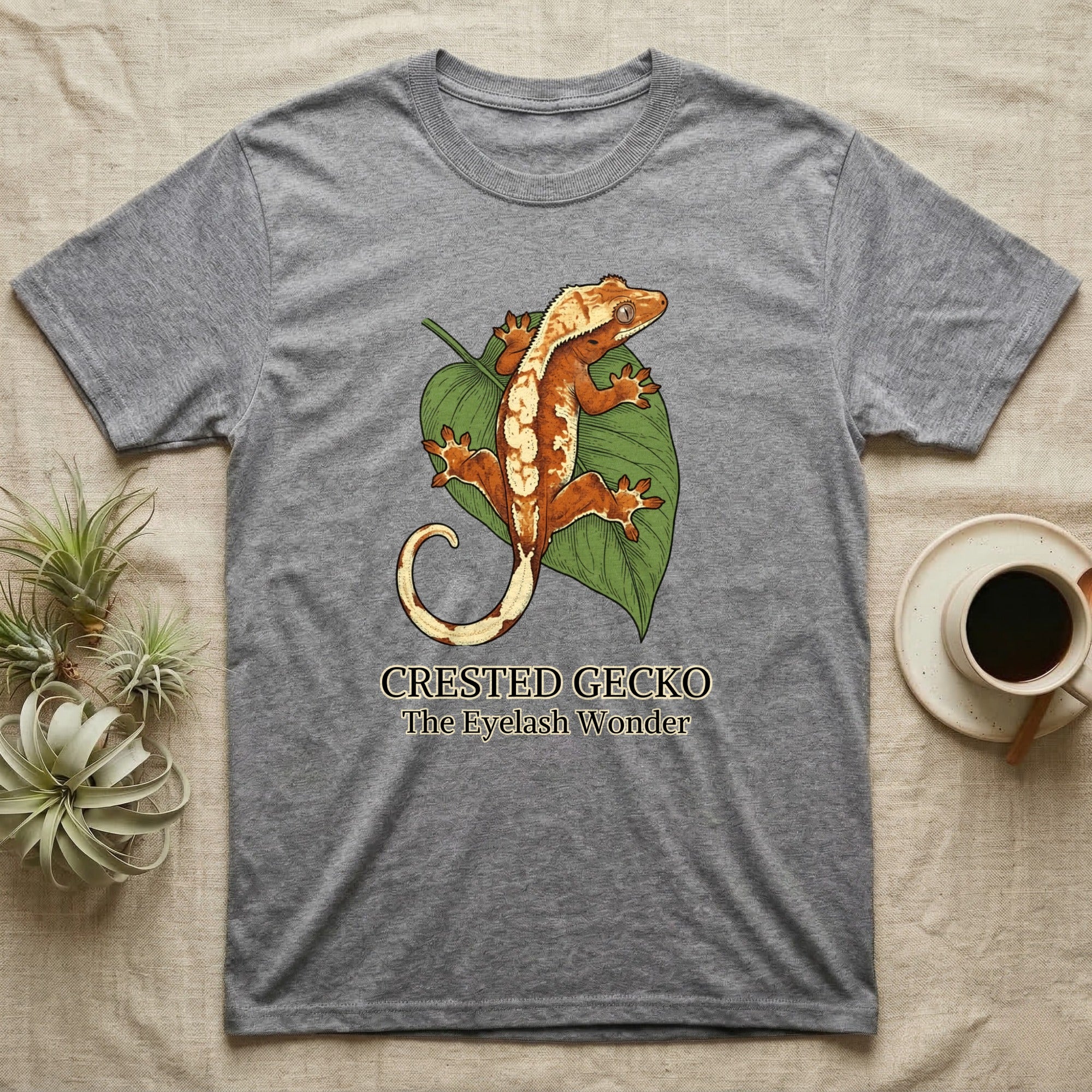 Grey t-shirt with a crested gecko illustration and text "CRESTED GECKO THE EYELASH WONDER".