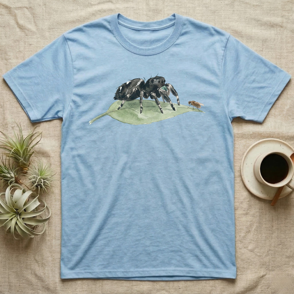 Jumping Spider Watercolour T-Shirt in Light Blue — Watercolour regal jumping spider standing still on a green leaf, watching a single fruit fly perched on the leaf's tip.