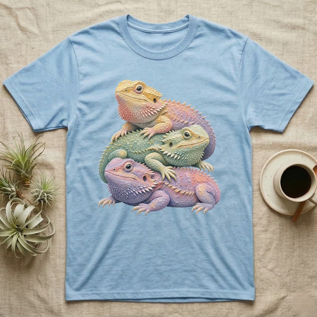 Three colorful bearded dragons stacked on a light blue t-shirt.