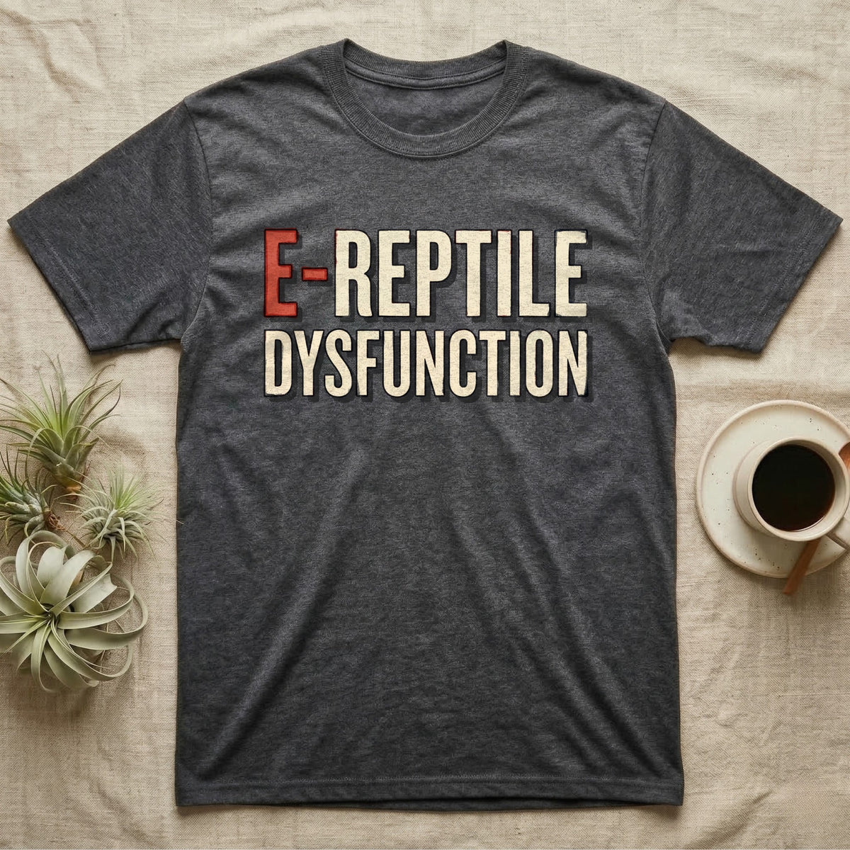 E-Reptile Dysfunction Gecko T-Shirt in Dark Heather — Retro-pharmacy typographic wordmark reading "E-Reptile Dysfunction" in distressed cream and tomato-red lettering.