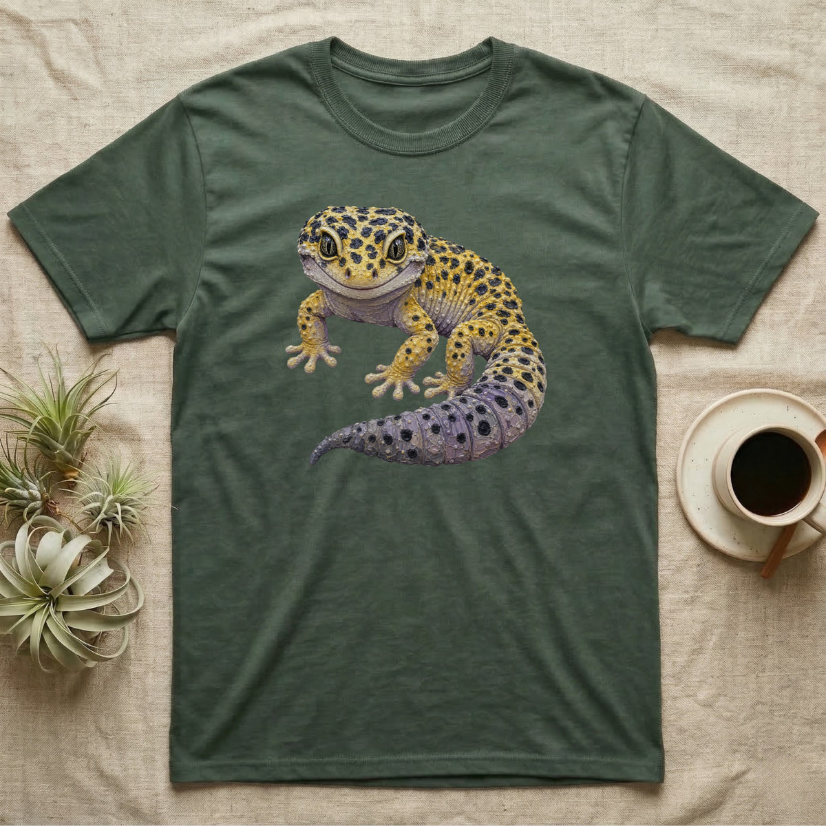 Green t-shirt with a cartoon leopard gecko graphic and small potted plants.
