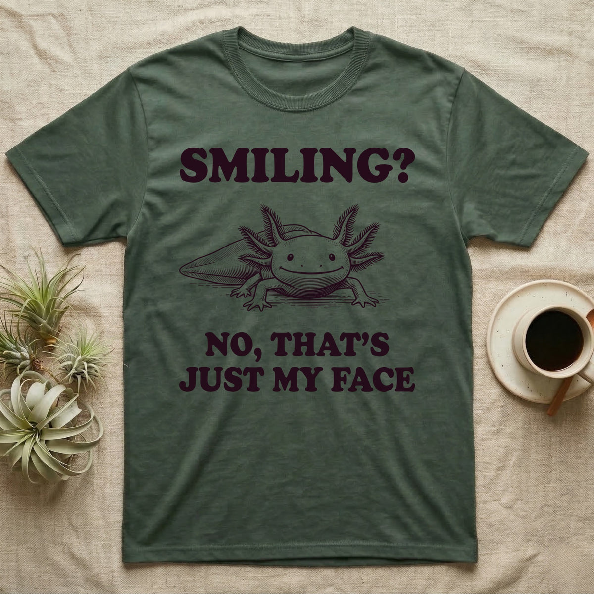 Axolotl Resting Face T-Shirt in Military Green — Engraved axolotl sitting head-on with gills fanned and a wide smile, with the words Smiling? No, That's Just My Face