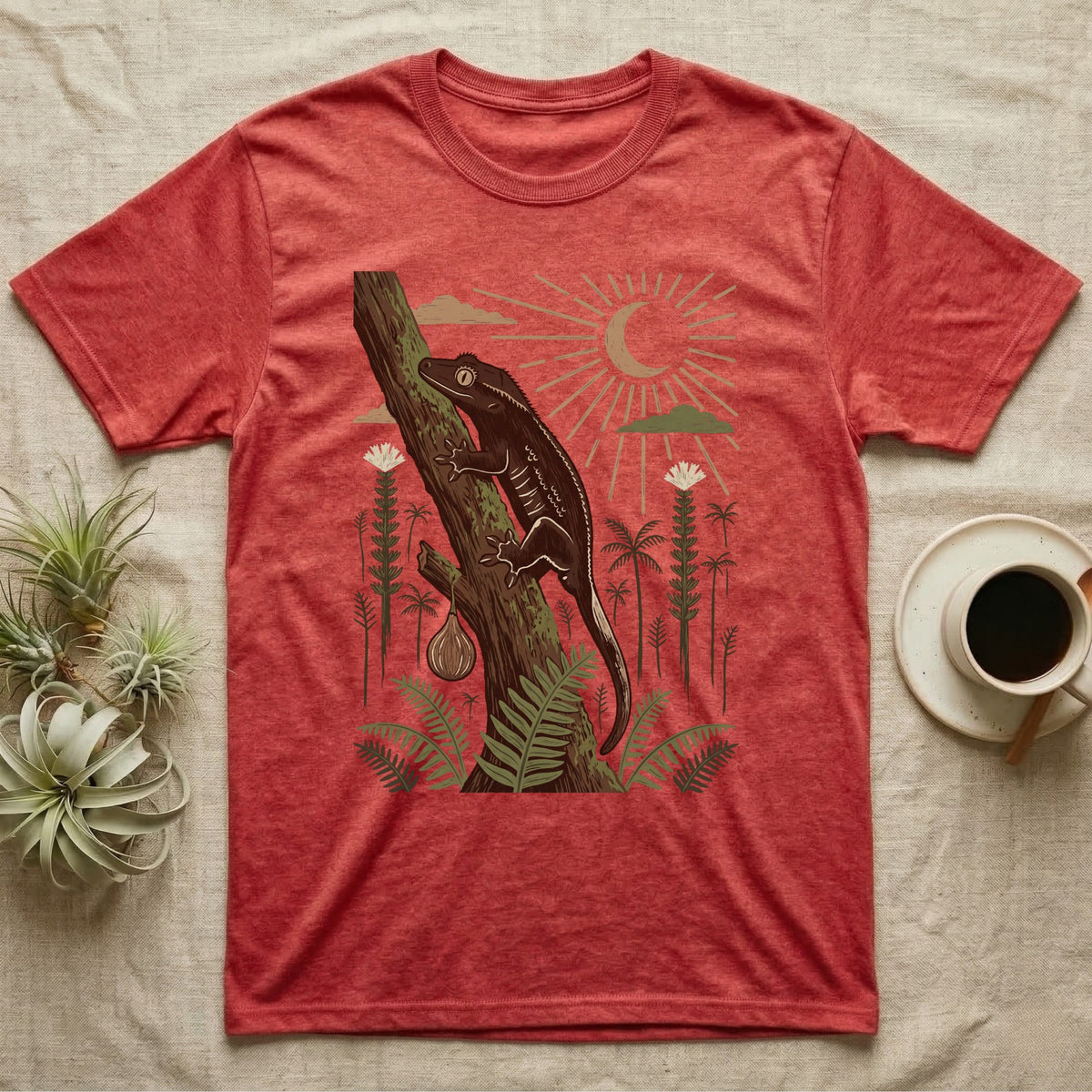 Crested Gecko Home Range T-Shirt in Heather Red — Woodcut-style illustration of a crested gecko clinging head-up to a mossy rainforest trunk among tree ferns, no on-shirt text.