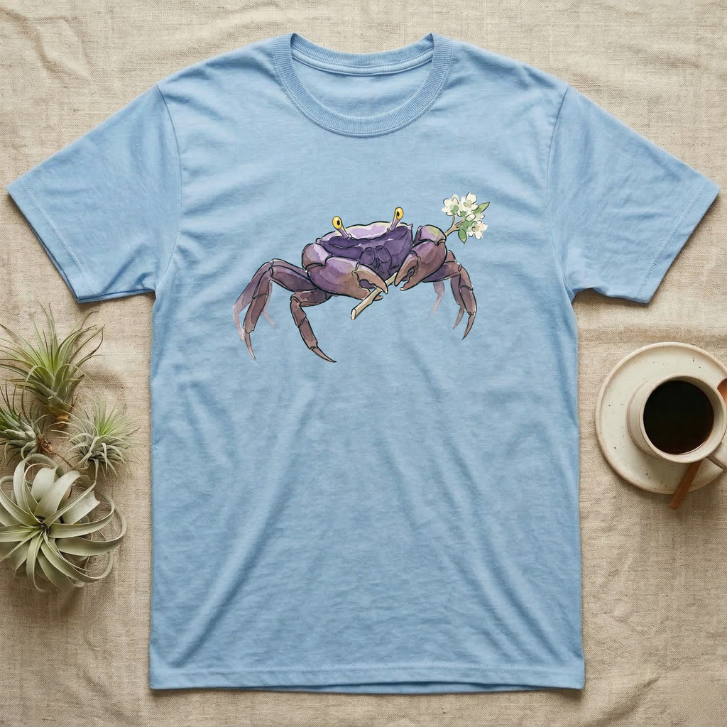 Vampire Crab Blossom T-Shirt in Light Blue — Watercolor illustration of a violet-purple vampire crab with yellow eye stalks holding a moss-flower blossom sprig, on a dark grey t-shirt.