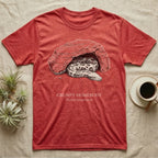 Blood Python Grumpy Homebody T-Shirt in Heather Red — Naturalist ink engraving of a blood python resting in a rock cave, captioned "Grumpy Homebody, Python brongersmai".
