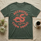 Corn Snake Recruit T-Shirt in Military Green — Hand-carved block-print badge of a corn snake on a branch inside ring lettering reading Recruited By One Corn Snake.
