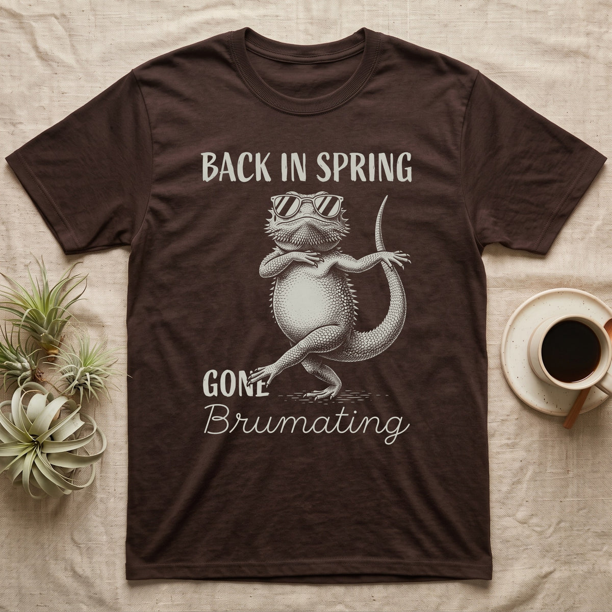 Bearded Dragon Brumating T-Shirt in Dark Chocolate — Bearded dragon in striped sunglasses doing a dance step, retro text reads Back In Spring, Gone Brumating