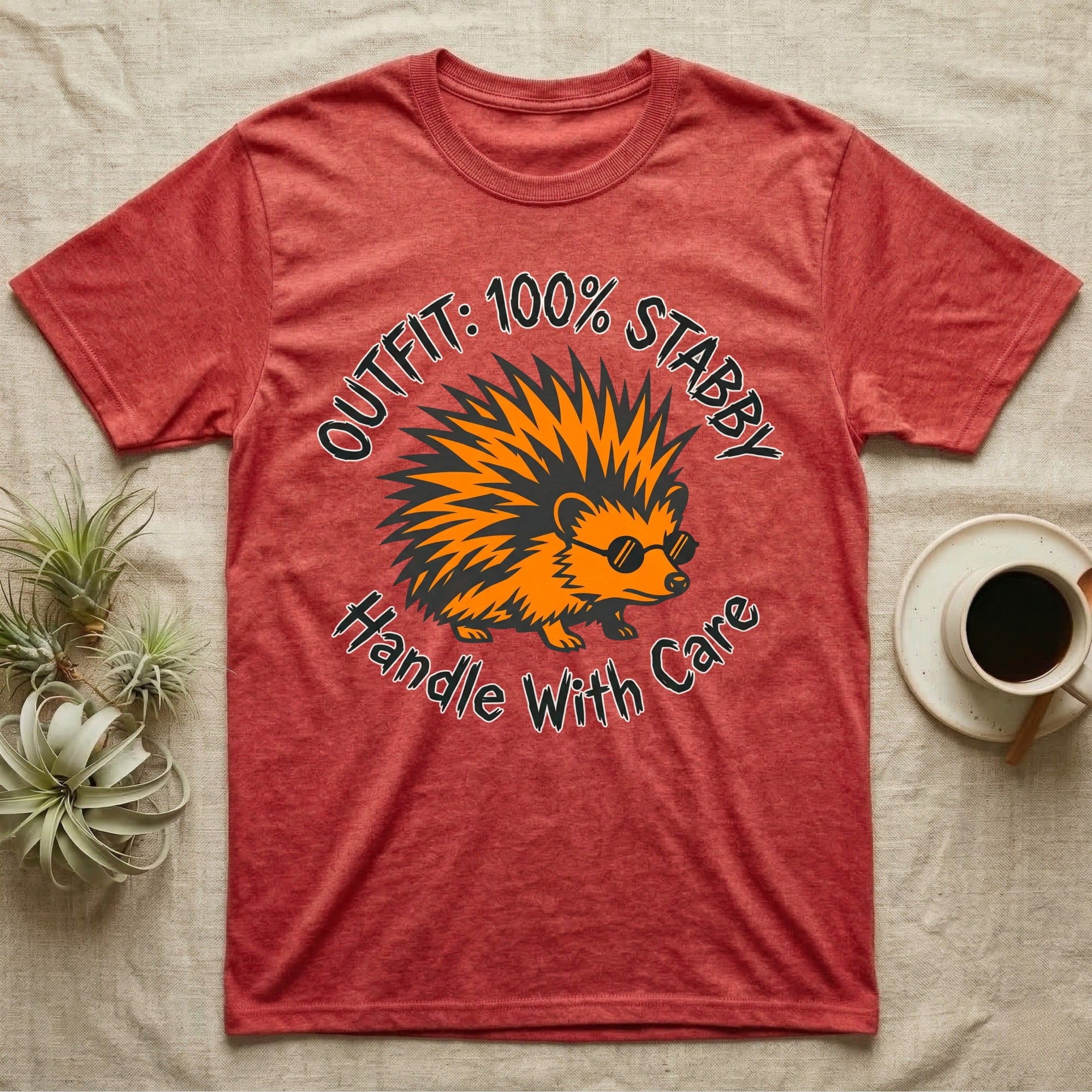 Red t-shirt with a cartoon hedgehog and text "OUTFIT: 100% STABBY. Handle With Care."