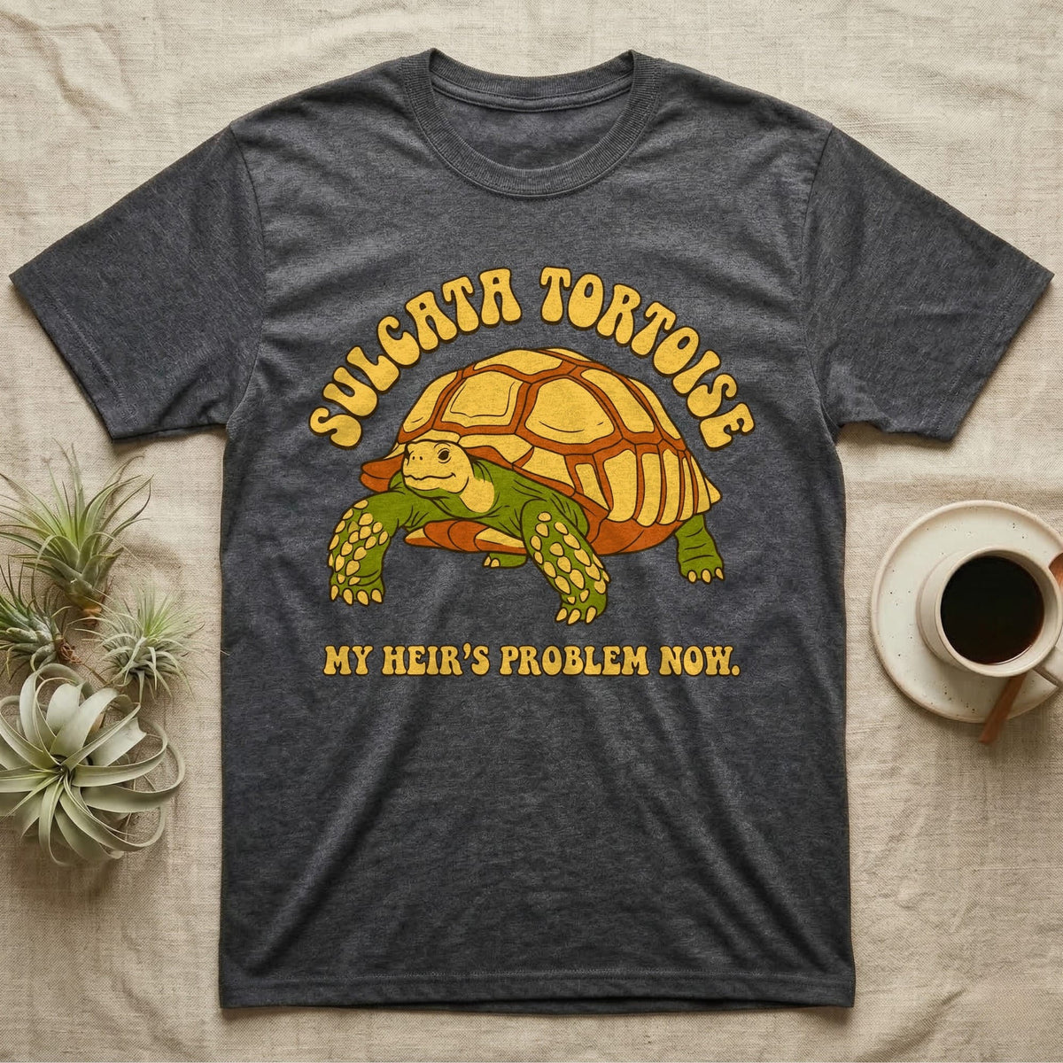 Dark grey t-shirt with Sulcata Tortoise and "MY HEIR'S PROBLEM NOW." text.