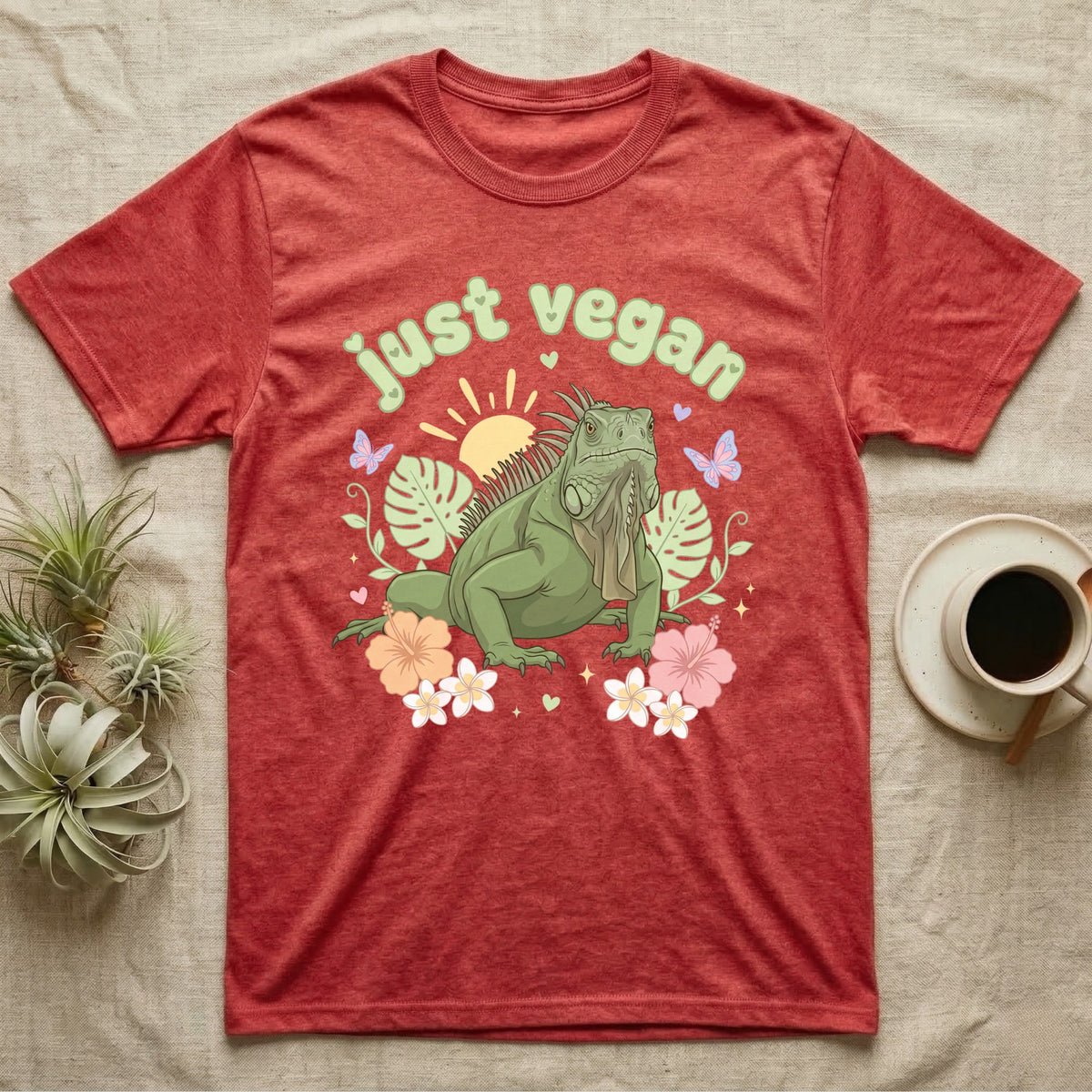 Green Iguana Baby T-Shirt in Heather Red — Green iguana with spiky crest and dewlap among pastel leaves and flowers under puffy green bubble text "just vegan".