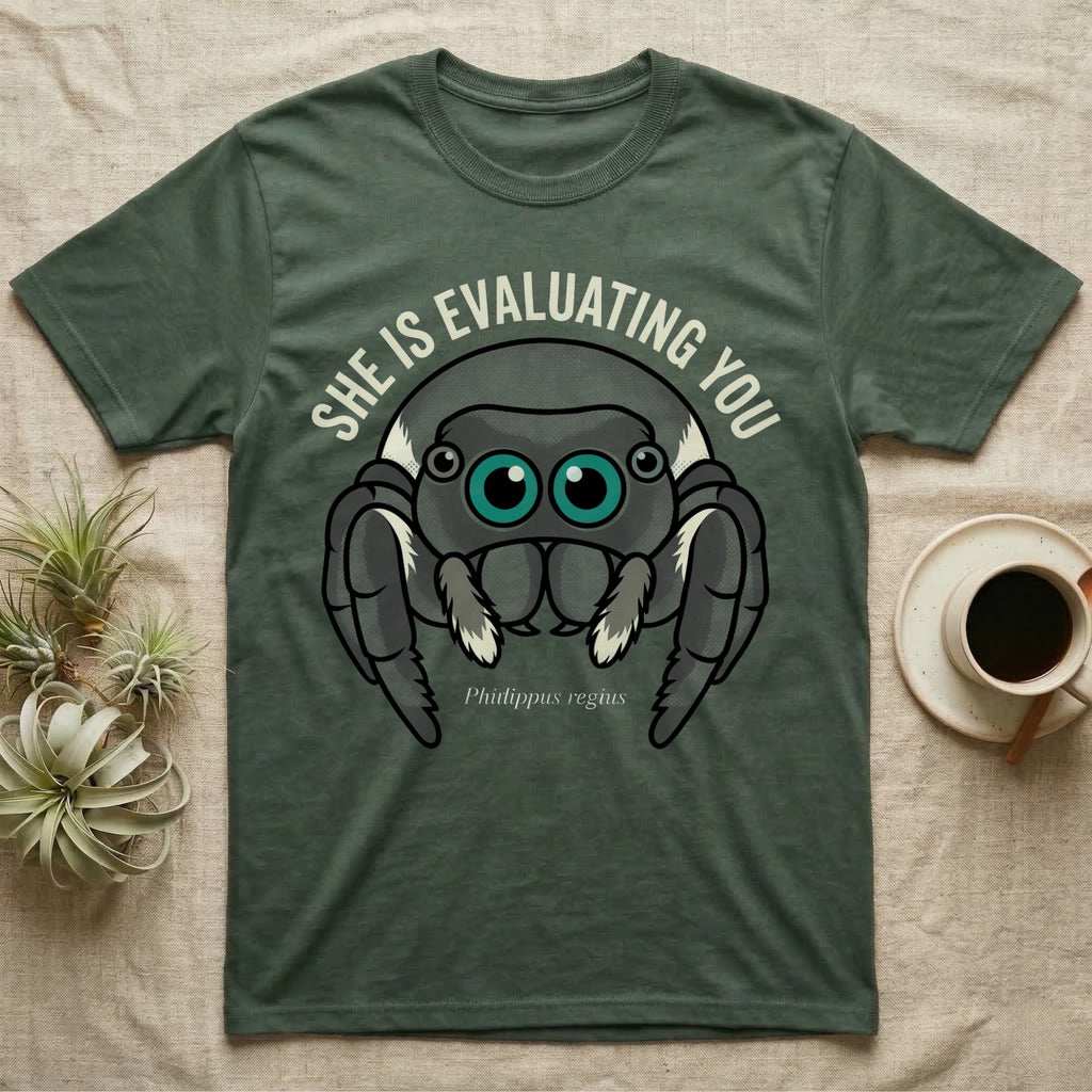 Phidippus Regius Jumping Spider Tee in Military Green — Vector-bold front-facing regal jumping spider portrait with electric-teal anterior-median eyes on a cream-and-charcoal body.