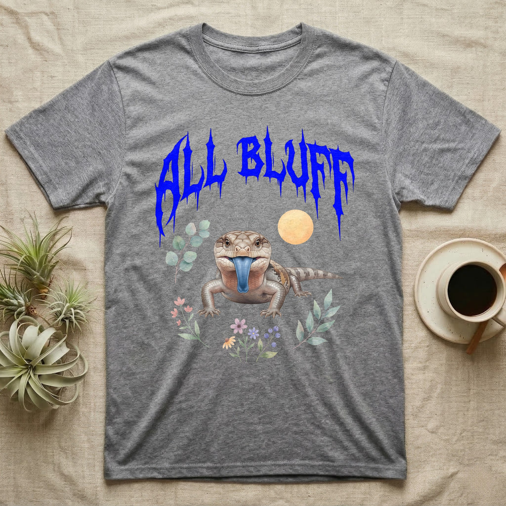 Northern Blue-Tongue Skink Feral T-Shirt in Sport Grey — Blue-tongue skink with its blue tongue out under a jagged cobalt-blue metal "ALL BLUFF" wordmark and pastel leaves.