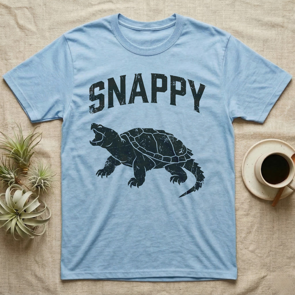 Snapping Turtle Snappy T-Shirt in Light Blue — Worn one-ink print of a common snapping turtle crouched side-on, jaws open mid-snap, under the arched word SNAPPY