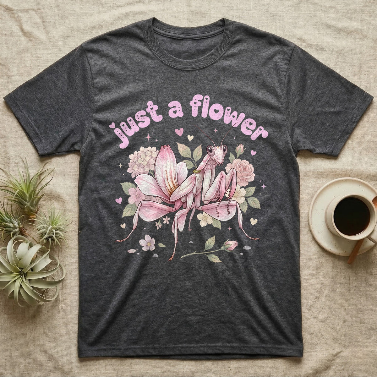 Orchid Mantis Softie T-Shirt in Dark Heather — Pink orchid mantis mimicking a flower under pastel bubble text "just a flower" with tiny hearts.