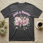 Orchid Mantis Softie T-Shirt in Dark Heather — Pink orchid mantis mimicking a flower under pastel bubble text "just a flower" with tiny hearts.