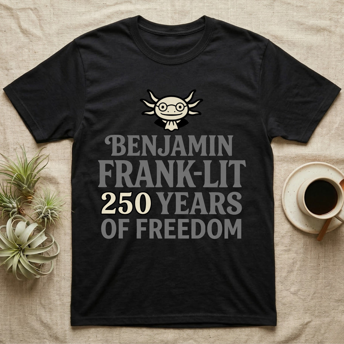 Axolotl Benjamin Franklin T-Shirt in Black — Flat cream axolotl as Ben Franklin in glasses above bold text reading Benjamin Frank-Lit, 250 Years of Freedom.