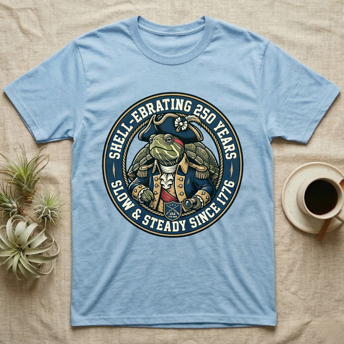 Sea Turtle General T-Shirt in Light Blue — Circular crest of a sea turtle dressed as a Continental general with text Shell-Ebrating 250 Years.