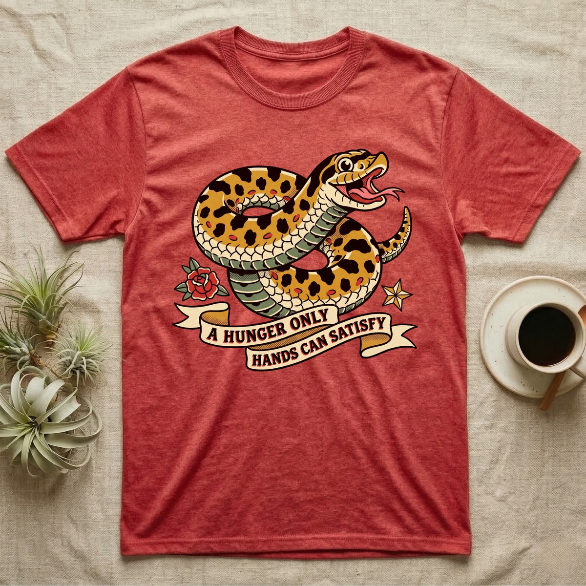Hognose Hunger Flash T-Shirt in Heather Red — American-traditional tattoo-flash illustration of a hognose snake in a heroic coil with a banner reading the feeding-hunger line.
