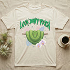 Green Tree Python Feral T-Shirt in Natural — Green tree python in a saddle coil on a branch under a jagged emerald metal "LOOK DON'T TOUCH" wordmark and orchids.