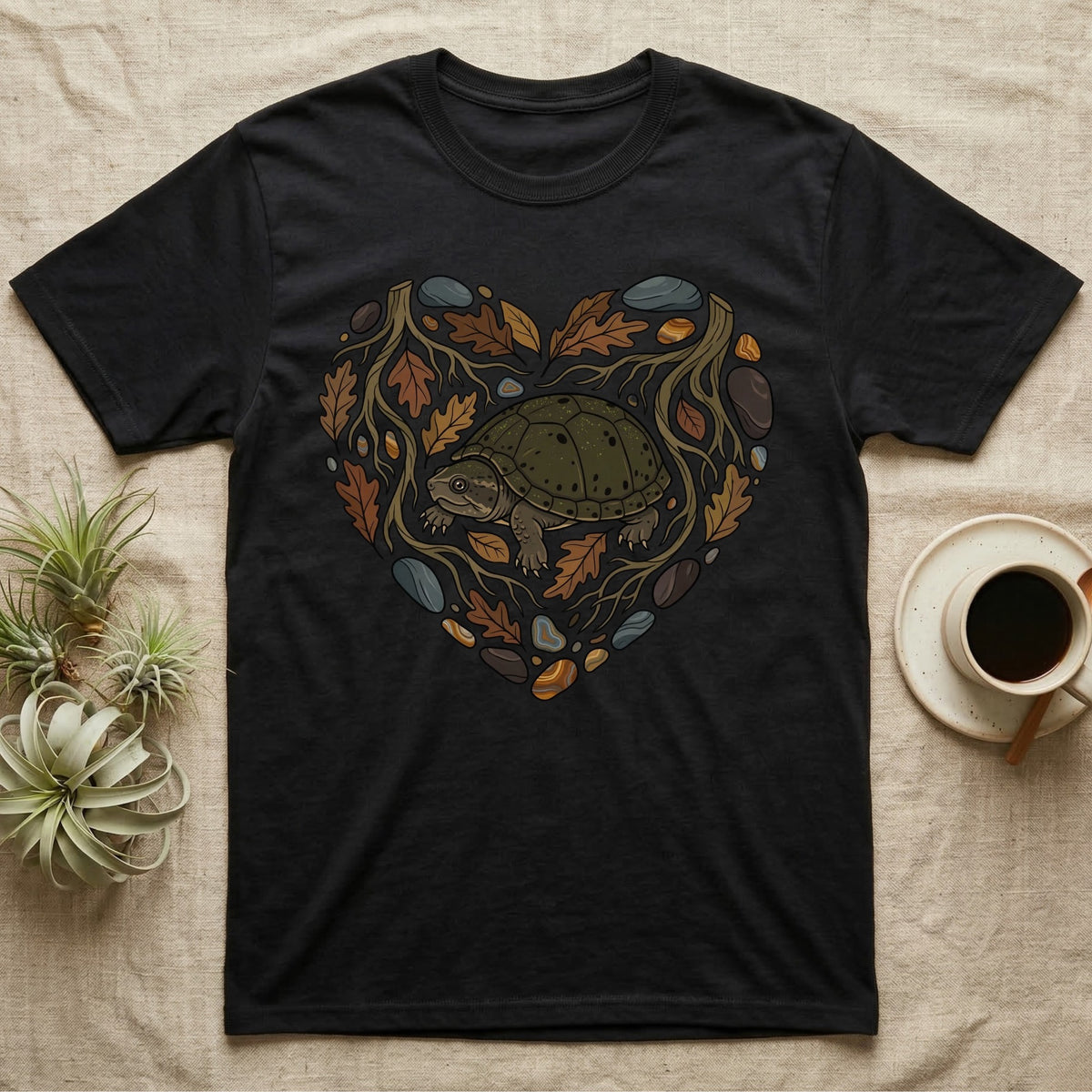 Black t-shirt with a heart-shaped graphic of a turtle surrounded by leaves and rocks.