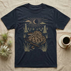 Ball Python Home Range T-Shirt in Navy — Woodcut-style illustration of a ball python coiled on dry savanna ground with grass tufts and termite mounds behind, no on-shirt text.