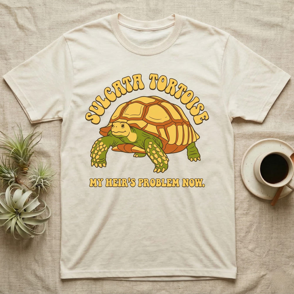 Cream t-shirt with Sulcata tortoise and text "MY HEIR'S PROBLEM NOW."