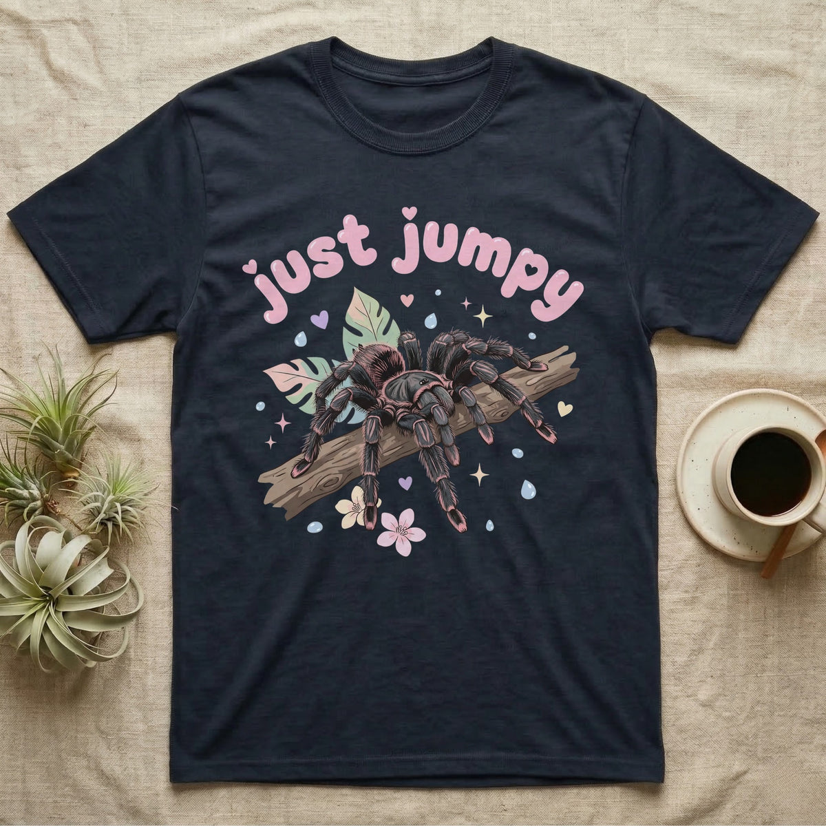 Pink Toe Tarantula Softie T-Shirt in Navy — Pink toe tarantula poised to leap on a branch under a puffy pastel "just jumpy" bubble wordmark with tiny hearts.