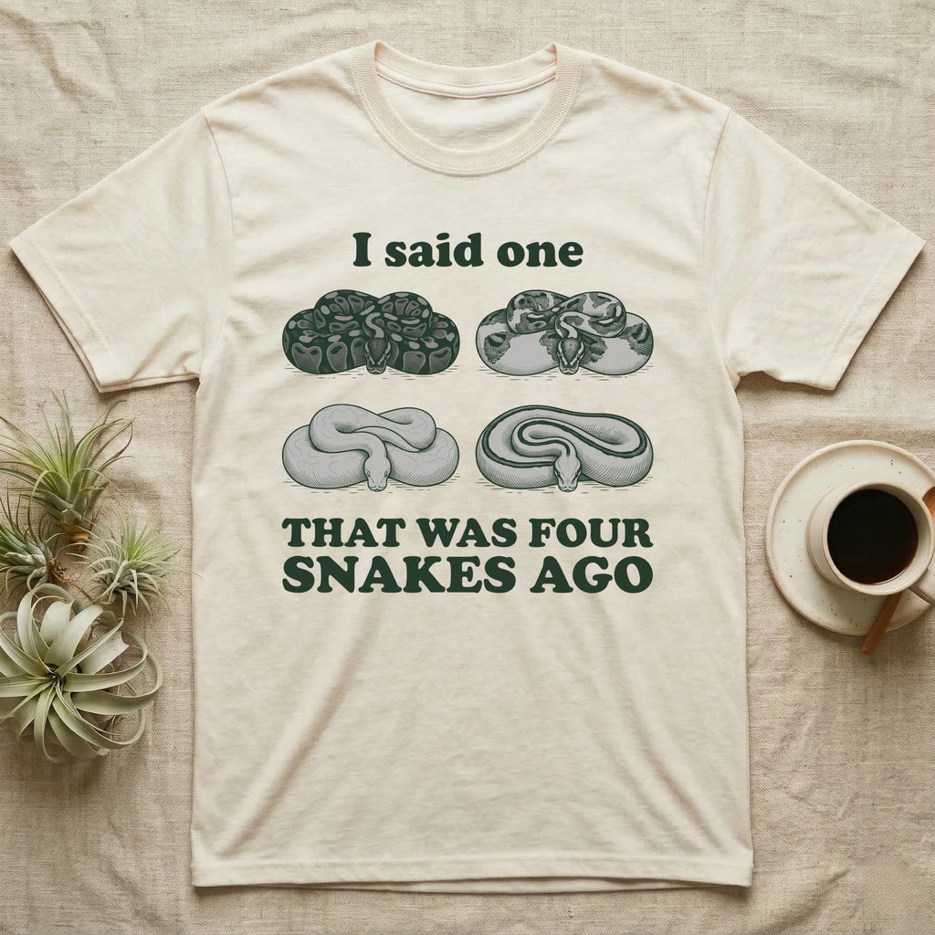 Ball Python Collector T-Shirt in Natural — Four engraved ball python morphs in tight coils between the words I said one and THAT WAS FOUR SNAKES AGO.