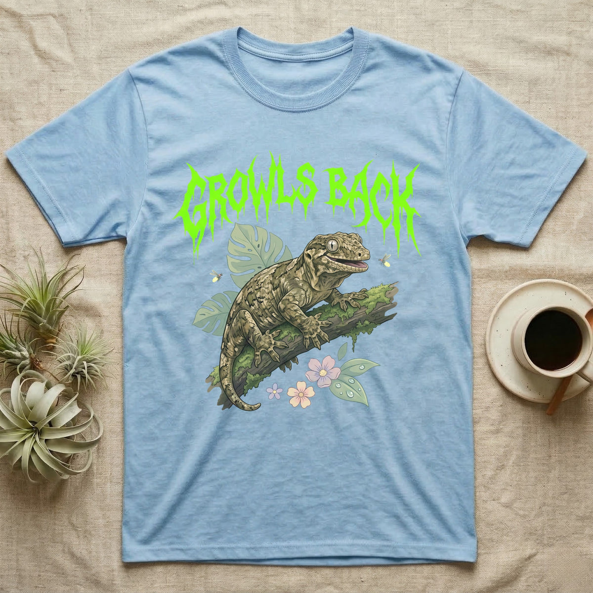 Leachianus Gecko Feral T-Shirt in Light Blue — Leachianus giant gecko on a mossy branch under jagged lime-green metal text GROWLS BACK with pastel leaves