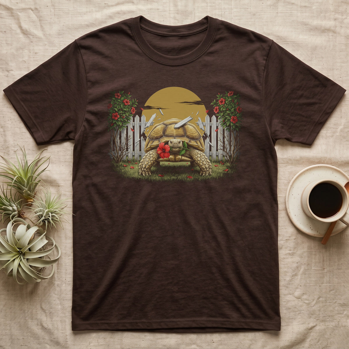 Sulcata Hibiscus Thief T-Shirt in Dark Chocolate — Painted 90s wildlife art of a sulcata tortoise walking through a broken picket fence with a red hibiscus flower in its beak