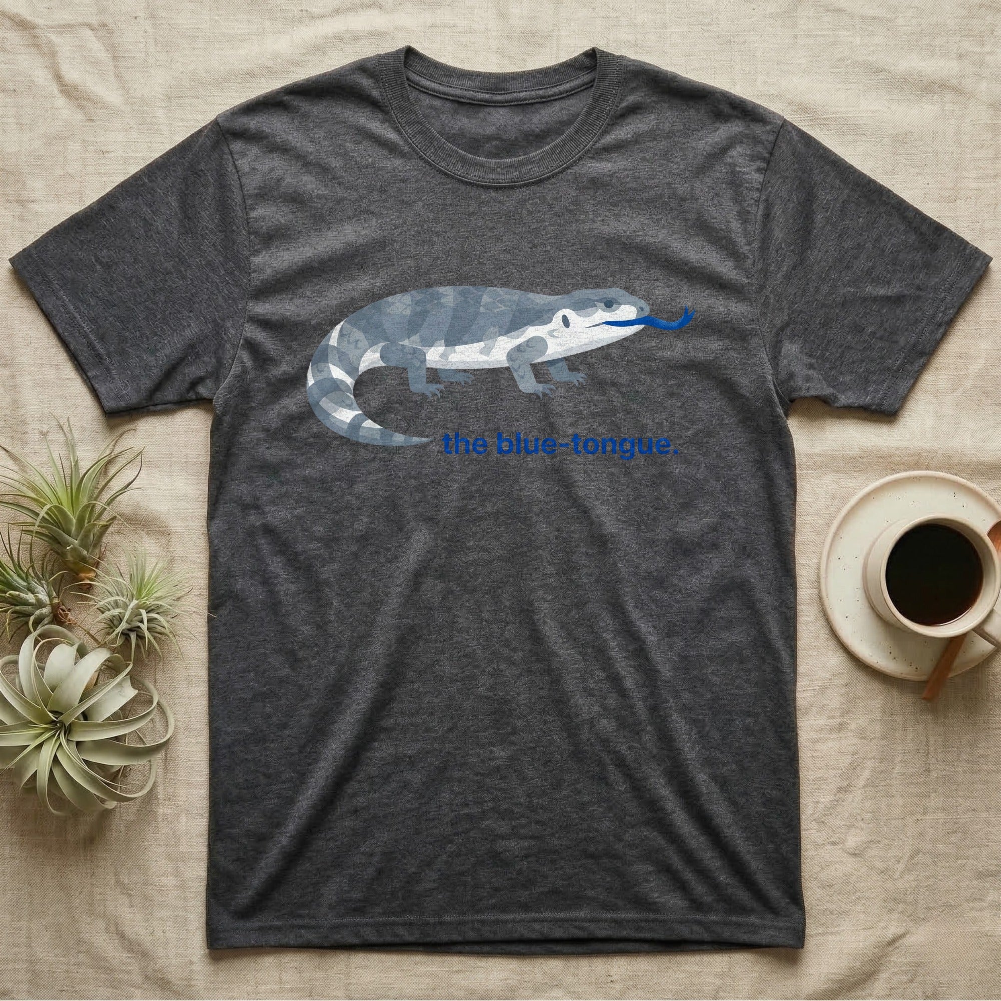 Dark grey t-shirt with a geometric blue-tongued lizard graphic and "the blue tongue."