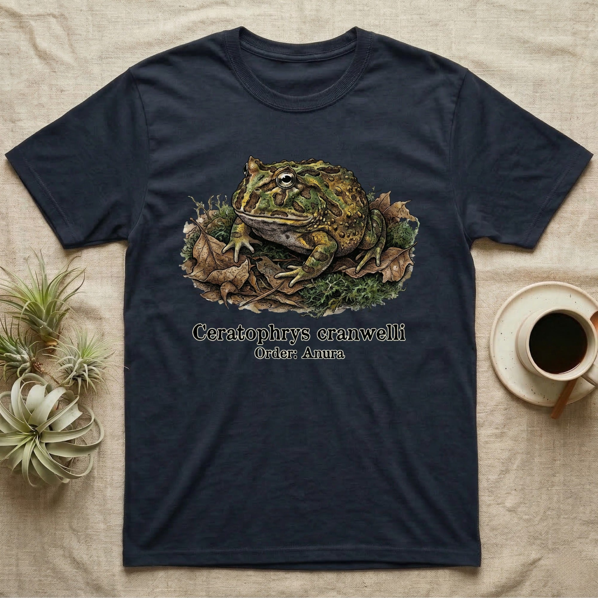 Navy t-shirt with illustration of Ceratophrys cranwelli frog on leaves.
