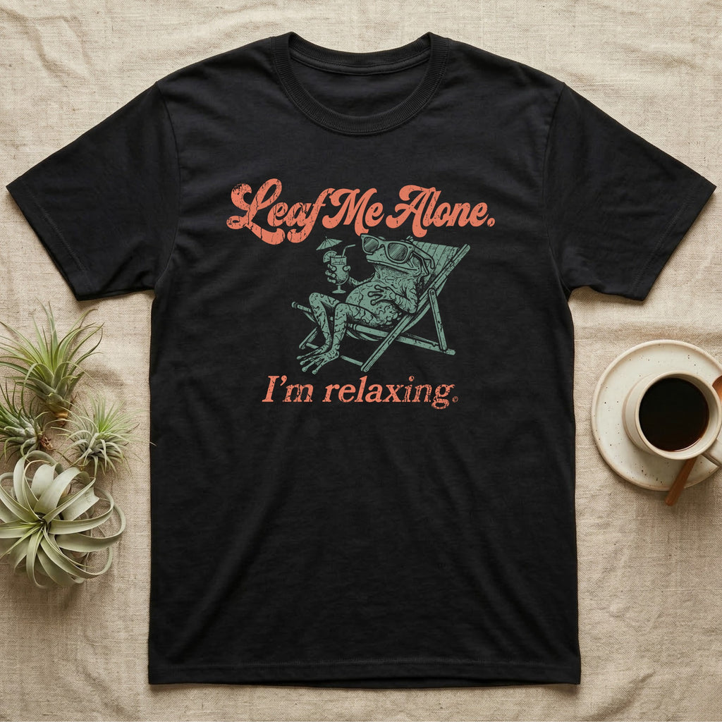 Solomon Islands Leaf Frog Chillin T-Shirt in Black — Illustrated Solomon Islands leaf frog reclining in a beach chair with sunglasses and a cocktail, coral script reading Leaf Me Alone I'm Relaxing.