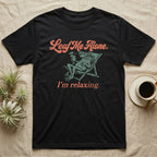 Solomon Islands Leaf Frog Chillin T-Shirt in Black — Illustrated Solomon Islands leaf frog reclining in a beach chair with sunglasses and a cocktail, coral script reading Leaf Me Alone I'm Relaxing.