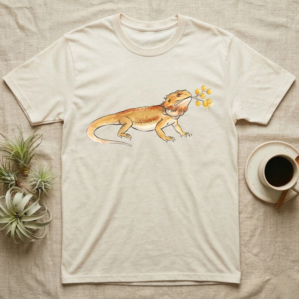 Bearded Dragon Blossom T-Shirt in Natural — Watercolor illustration of an ochre bearded dragon holding a golden wattle blossom sprig, on a dark grey t-shirt.