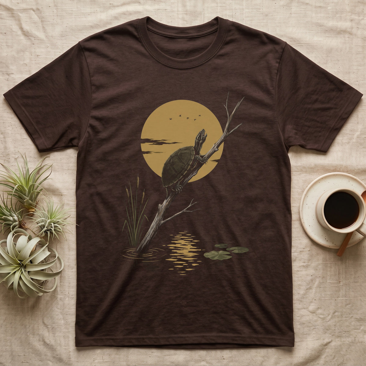 Musk Turtle Moon T-Shirt in Dark Chocolate — Painted 90s wildlife art of a musk turtle on a bare branch howling at a big golden moon behind it, cattails and lily pads below, on black