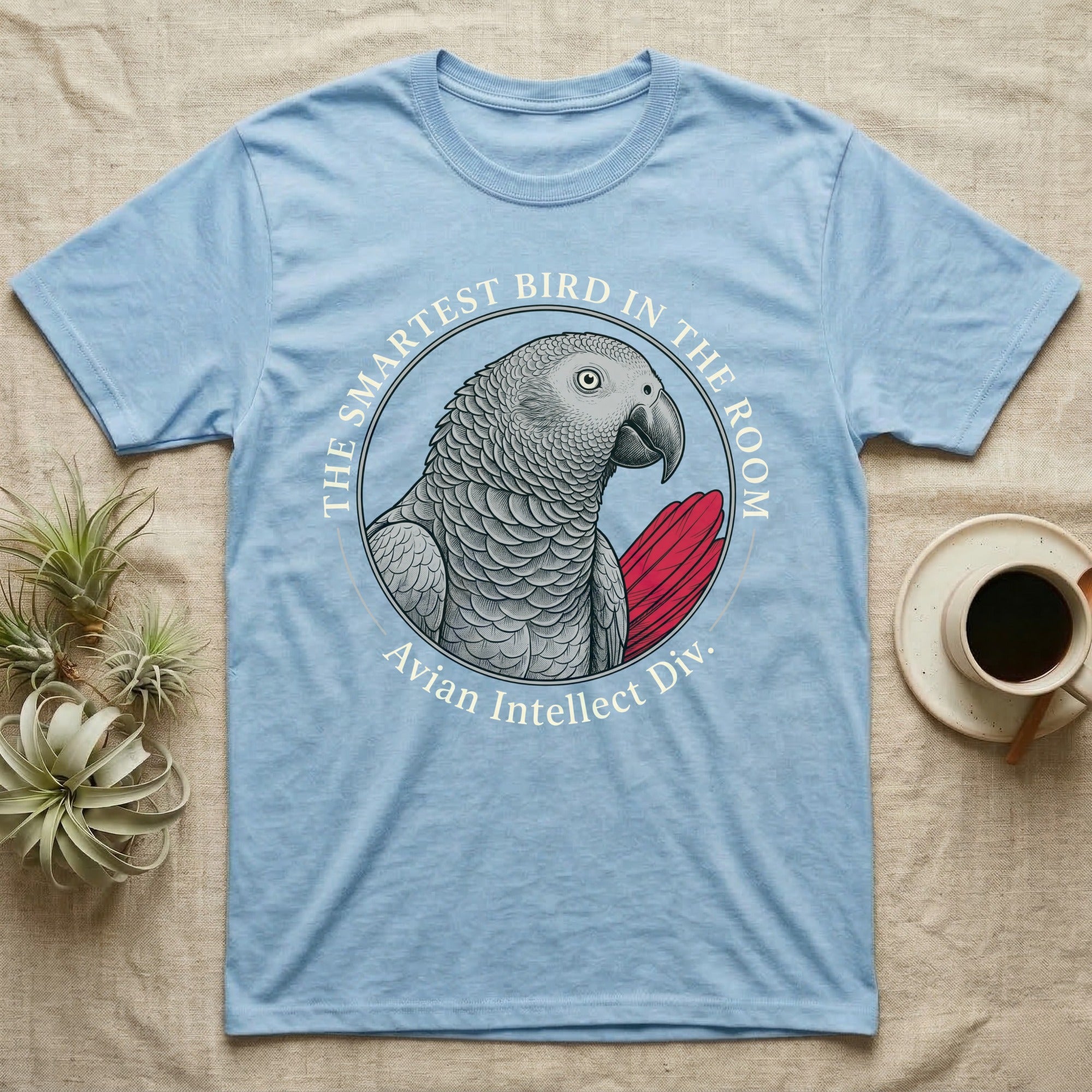 Light blue t-shirt with a grey parrot graphic and text "The Smartest Bird in the Room".