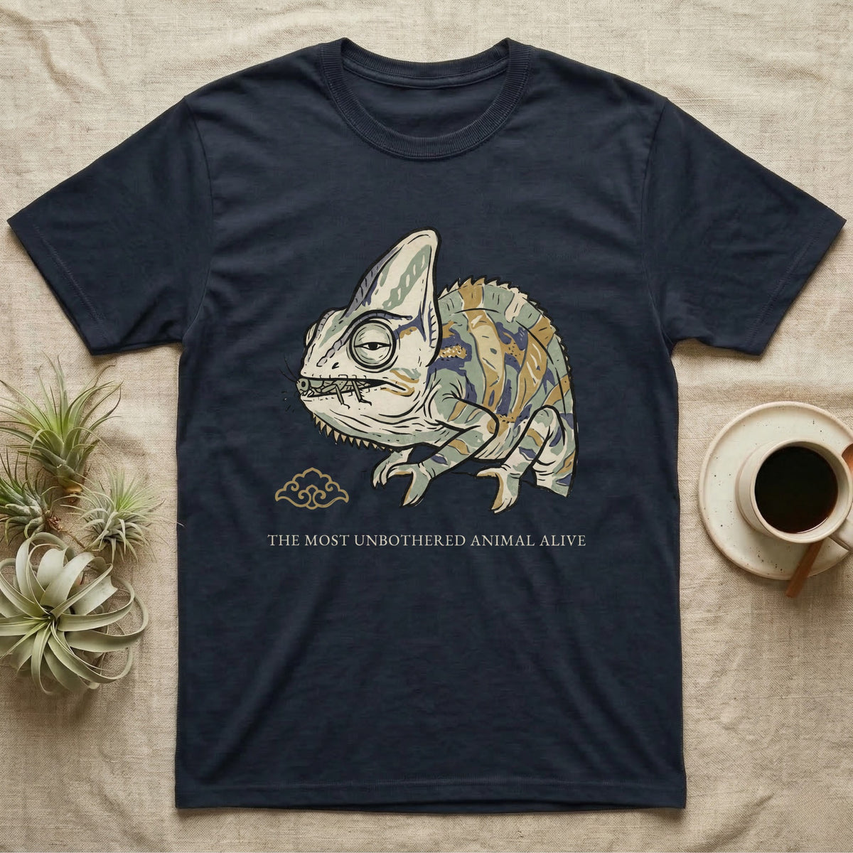 Unbothered Chameleon T-Shirt in Navy — Ukiyo-e woodblock illustration of a veiled chameleon mid-chew with a deadpan serif caption beneath the subject.