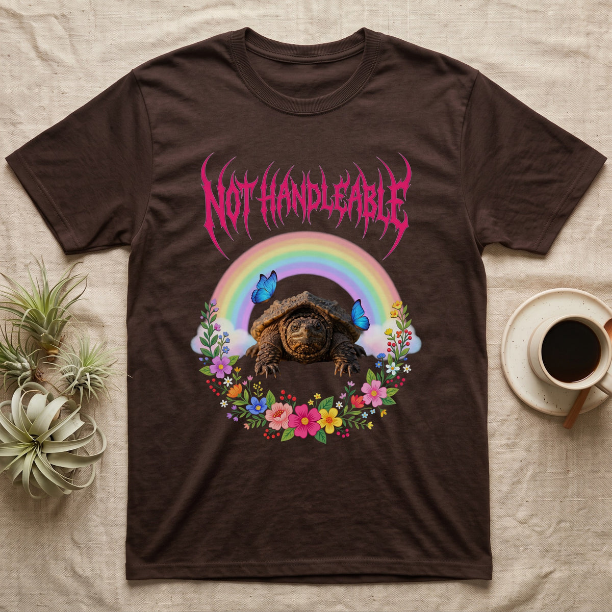 Snapping Turtle Hatchling T-Shirt in Dark Chocolate — Cute baby snapping turtle in a pastel rainbow and flower wreath under a hot pink metal logo reading NOT HANDLEABLE