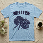 Hermit Crab Shellfish T-Shirt in Light Blue — Worn purple one-ink print of a hermit crab hugging a big spare shell to its chest under the word Shellfish