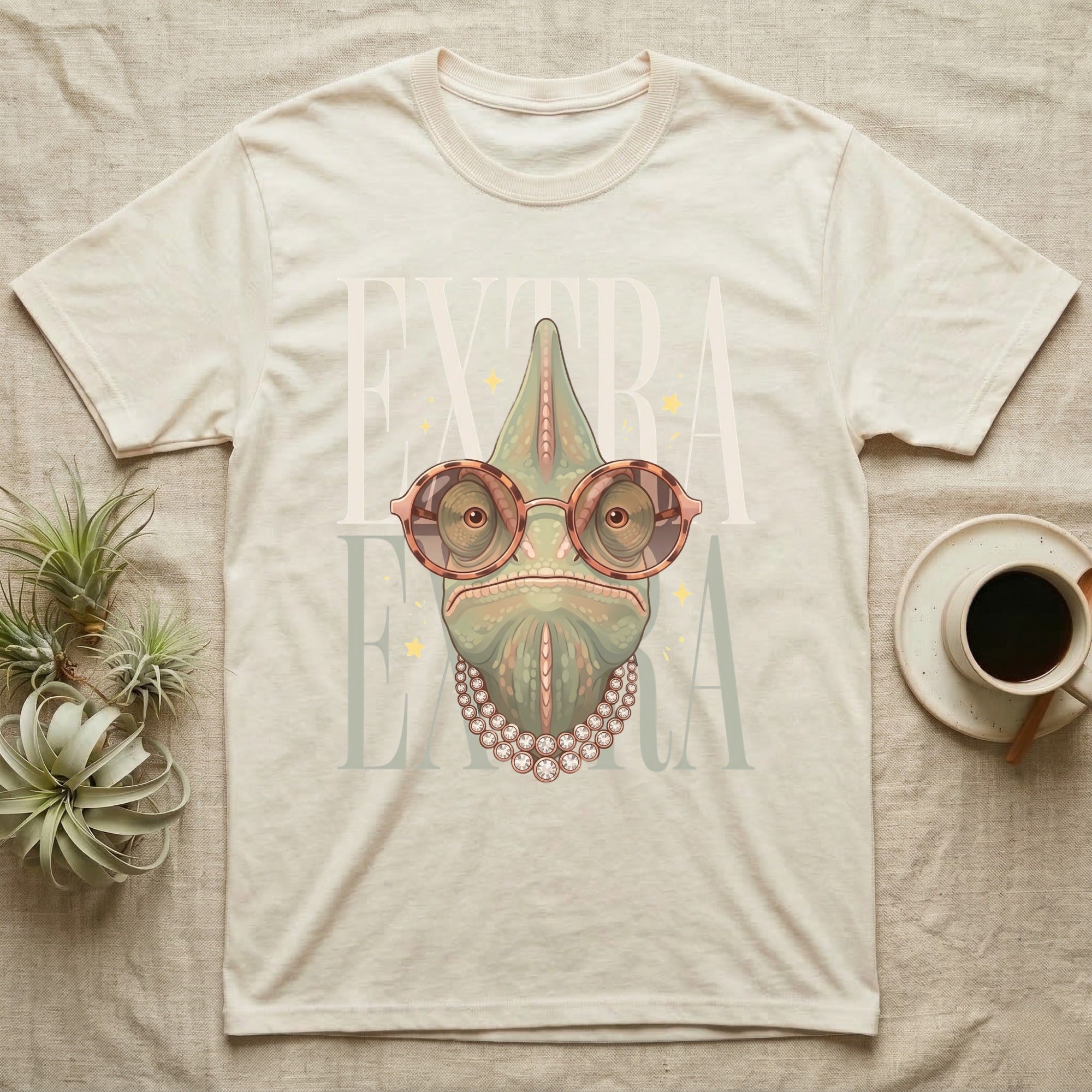 Chameleon wearing oversized glasses and pearl necklace on a light cream t-shirt.