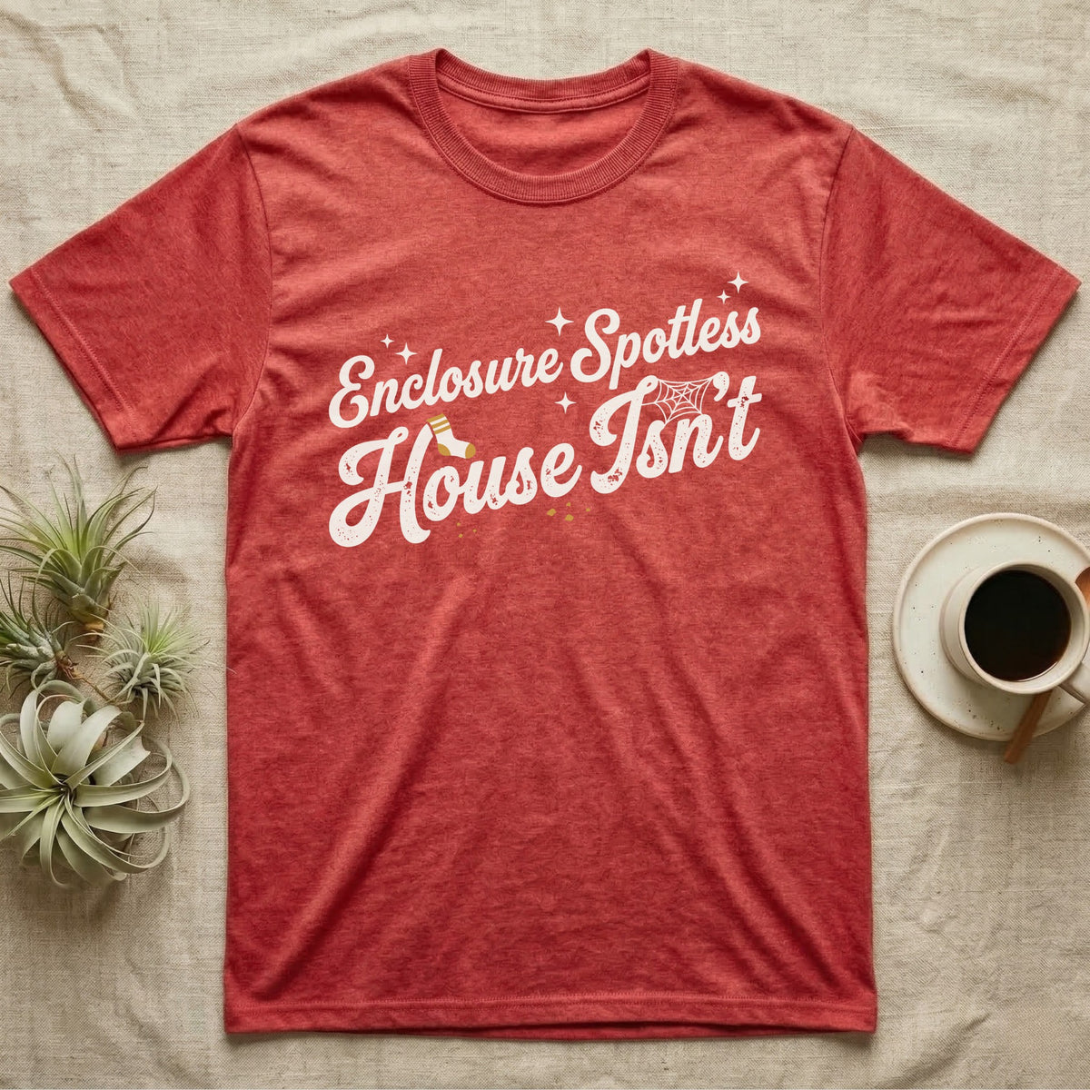 Terrarium Spotless House T-Shirt in Heather Red — Retro script reading Enclosure Spotless with sparkles above grubby lettering reading House Isn't with a sock, cobweb and crumbs