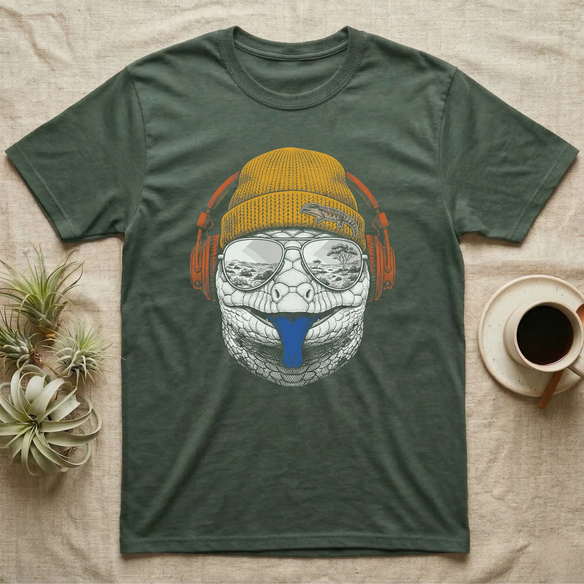 Blue-Tongued Skink Headphones T-Shirt in Military Green — Engraved blue-tongued skink with cobalt tongue out, wearing a beanie and headphones, aviators reflecting the outback.