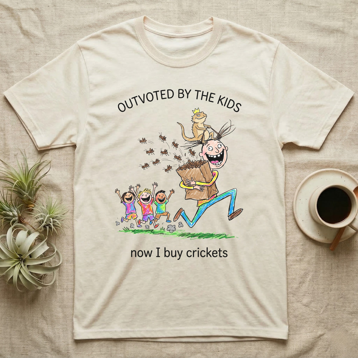 Lizard Dad Outvoted T-Shirt in Natural — Crayon drawing of a crowned bearded dragon riding a grinning dad who carries a bag of crickets while three kids cheer, under Outvoted By The Kids, now I buy crickets