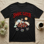 California Kingsnake Feral T-Shirt in Black — Banded California kingsnake coiled with a tiny companion snake under a jagged blood-red metal wordmark and pastel scene.