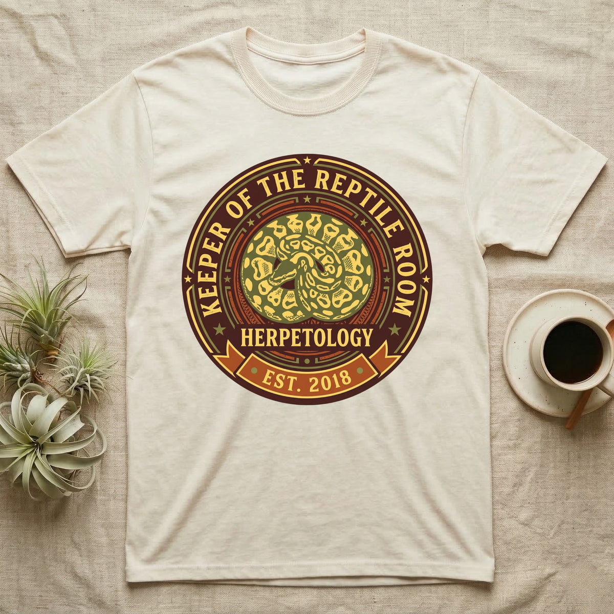 Cream t-shirt with circular "Keeper of the Reptile Room Herpetology Est. 2018" logo.